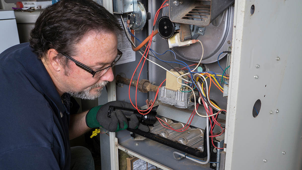 Man checking inside of furnace